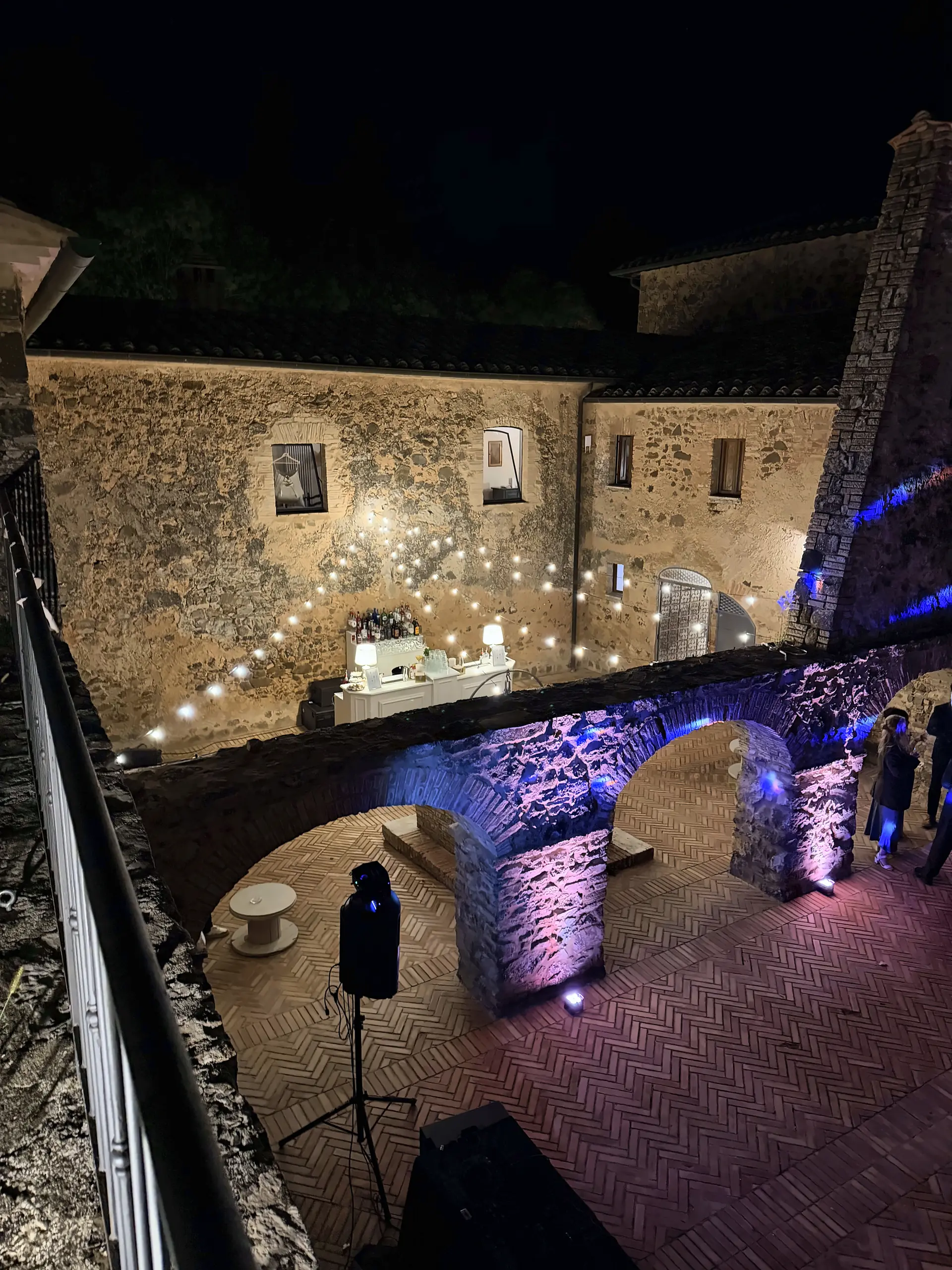 The convent courtyard lit at night, with the bar in the background