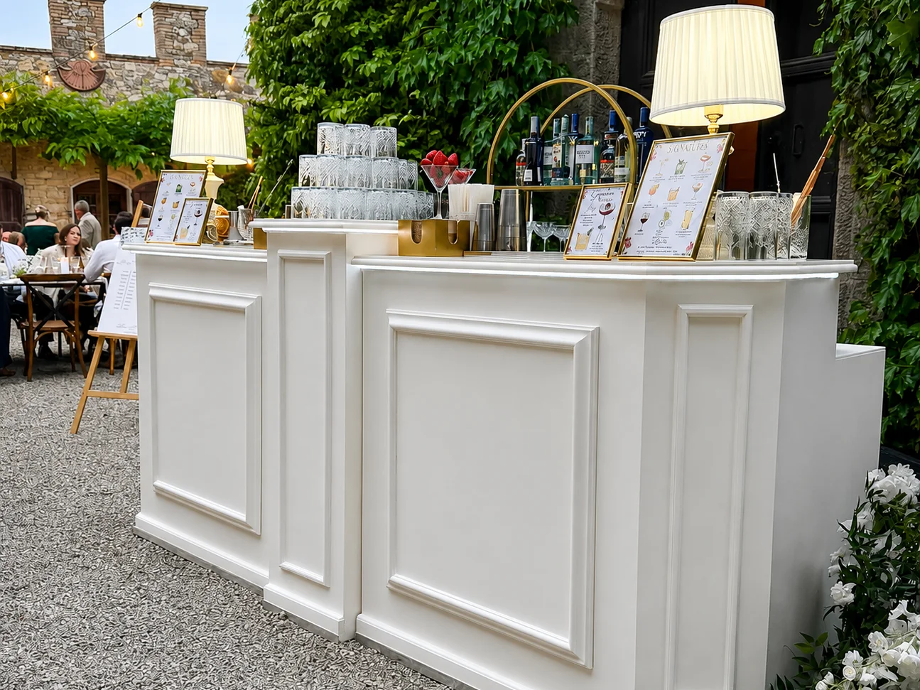 Bancone modulare Just Drink in legno bianco allestito in un cortile toscano