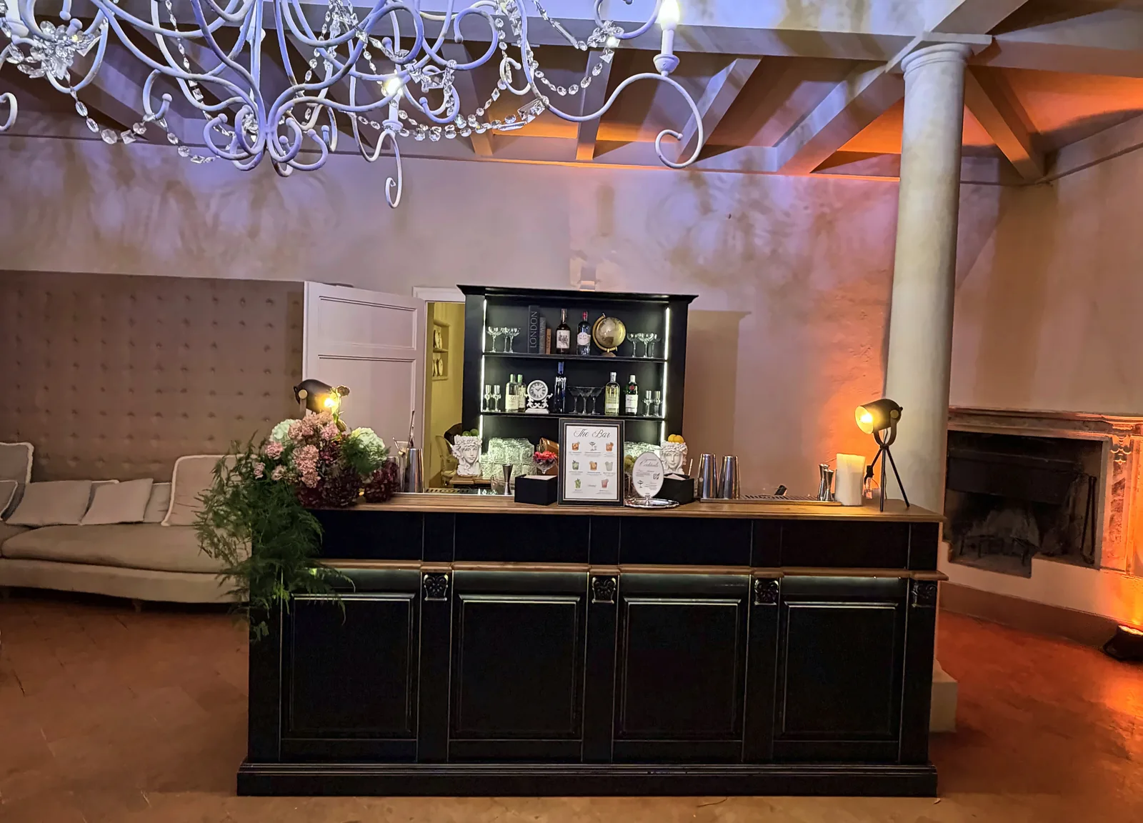 Black bar counter set up under the chandelier at Villa di Ulignano