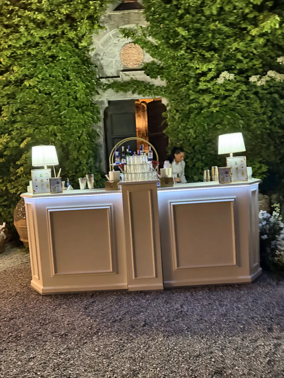 Illuminated bar at sunset in the courtyard of Castello di Montalto