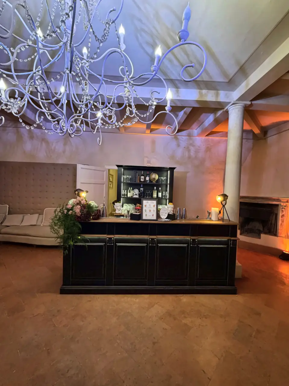Black bar counter set up under the chandelier at Villa di Ulignano