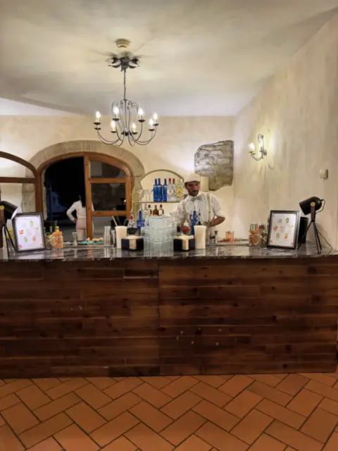 The bar room of Villa Il Granduca with chandelier and terracotta floor