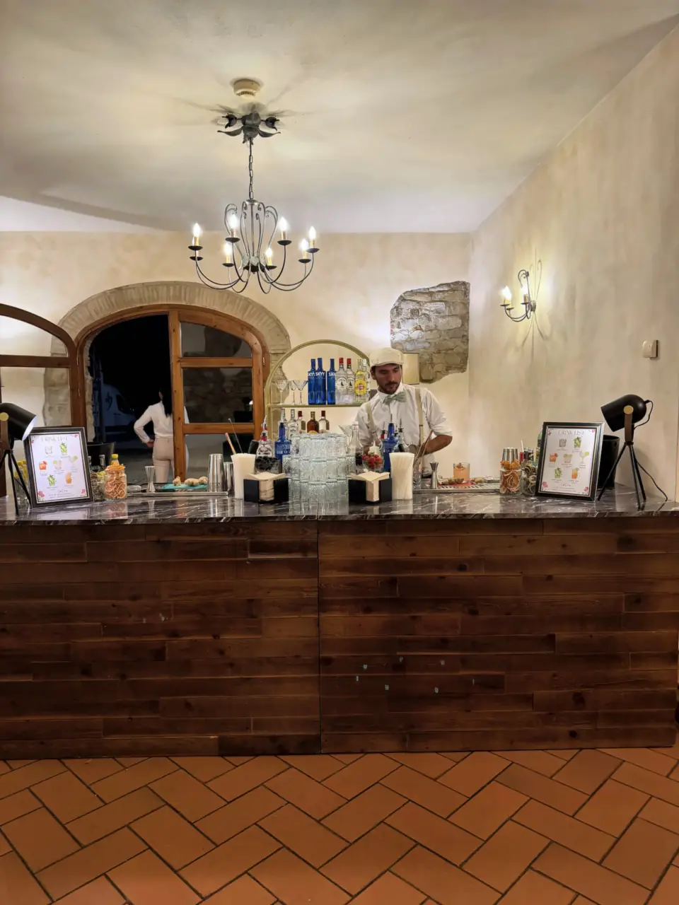 The bar room of Villa Il Granduca with chandelier and terracotta floor
