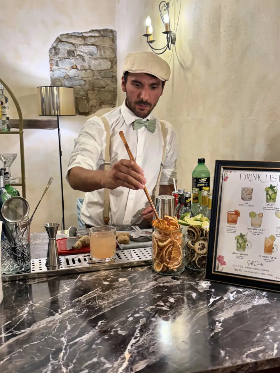 Just Drink bartender stirring a cocktail with dried citrus